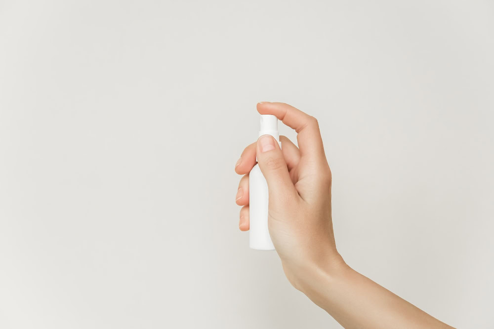 female spraying bottle