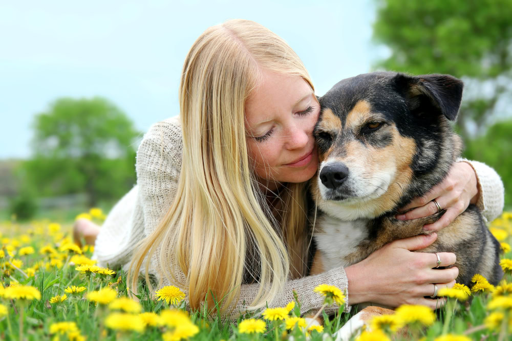 owner hugging dog outdoors