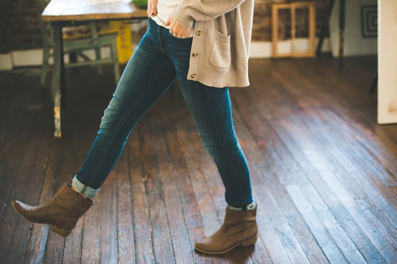 Girl in boots walking on hardwood floor