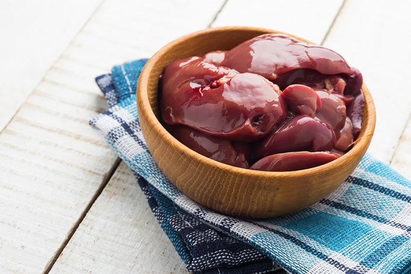 Raw chicken liver in bowl on white table