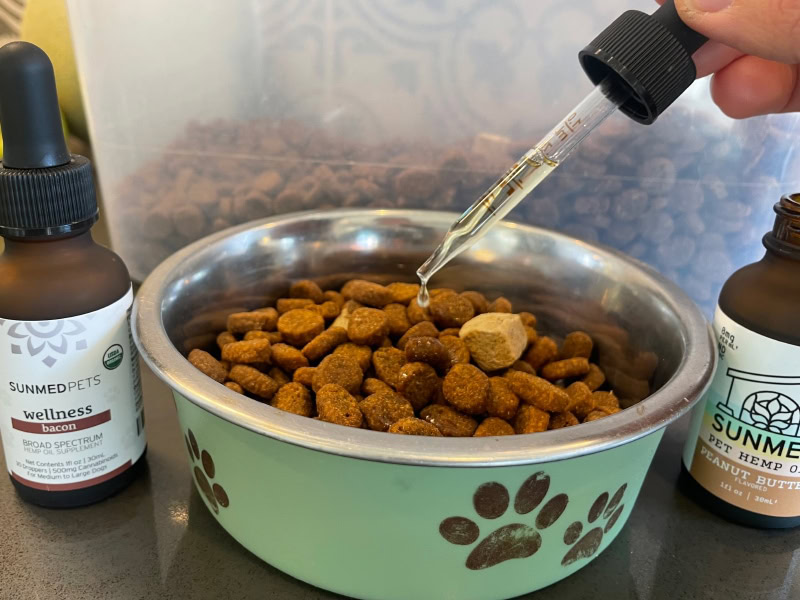 Sunmed Pet CBD Products - dropping cbd oil to a bowl of dog food