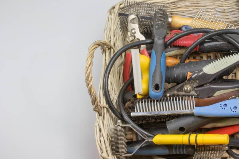 Used tools and supplies for a dog grooming are in knitted basket