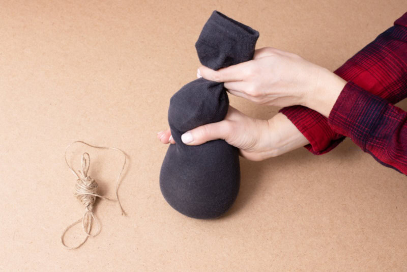 Woman tying a sock filled with litter