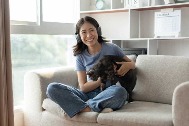 Woman with Black American Shorthair cat on the couch