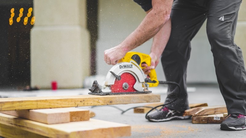 a man working at a construction site and cutting wood