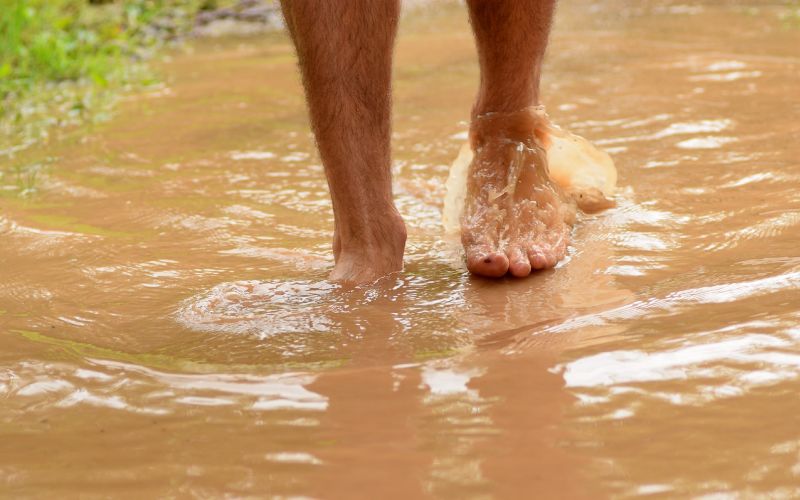 a person wading through brown flood water