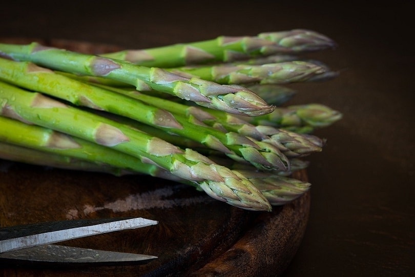 asparagus and scissors on wooden platform