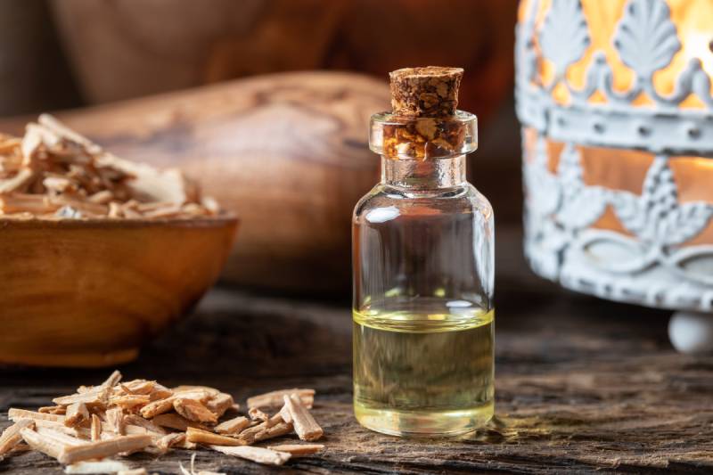 bottle of essential oil with cedar wood chips