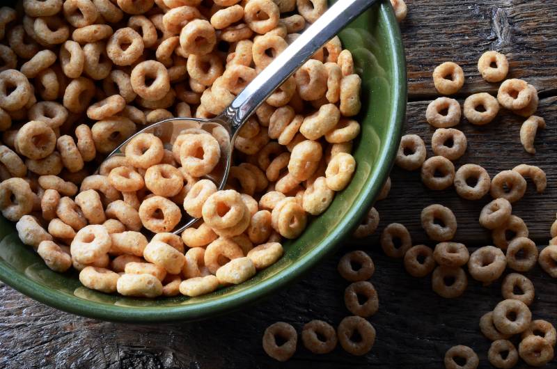 close up image of a bowl of cereal with cereal spilled on the table surface