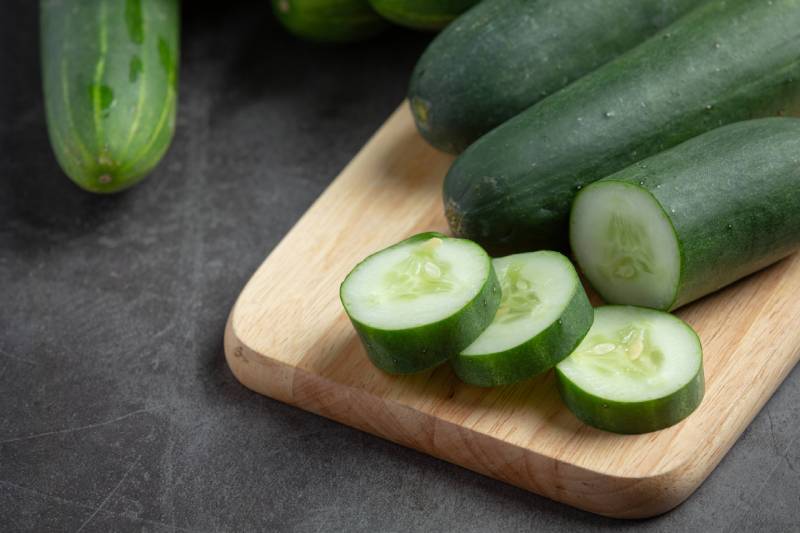 fresh cucumbers sliced on dark background