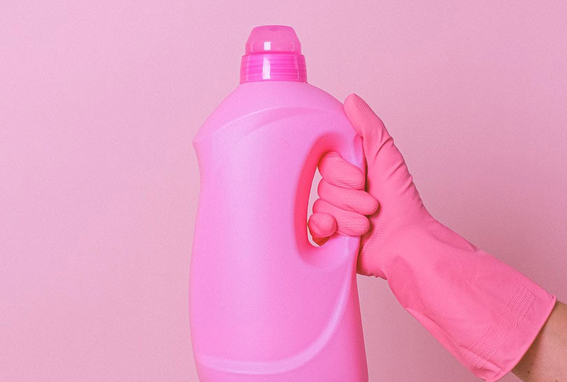 hand with pink gloves holding up a fabric softener