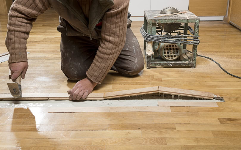 man fixing wooden floor