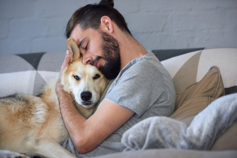 man hugging his dog