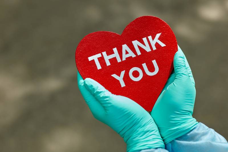 medical staff holding a thank you card