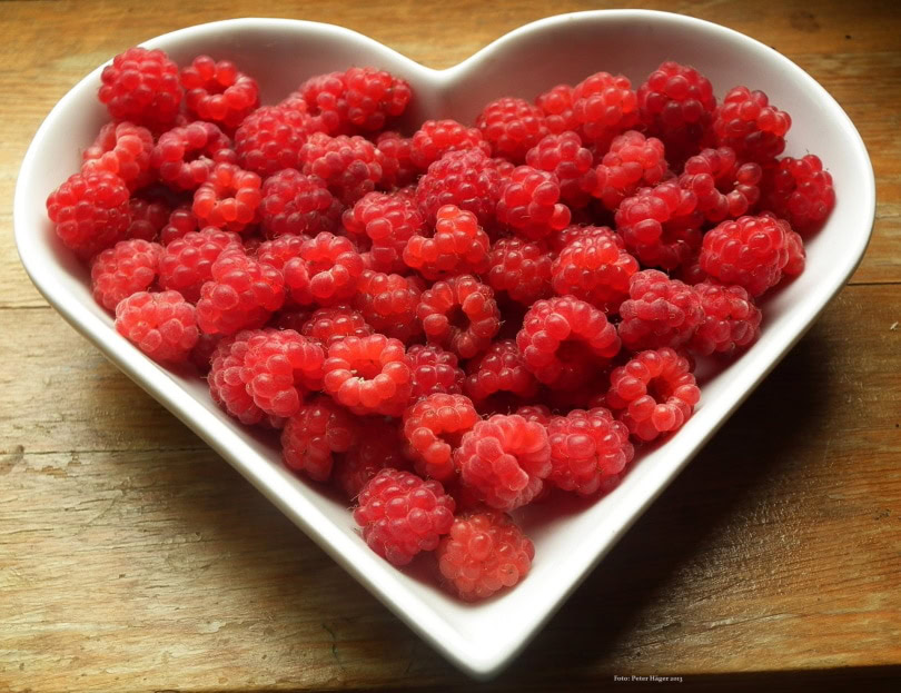 raspberries in heart shape bowl