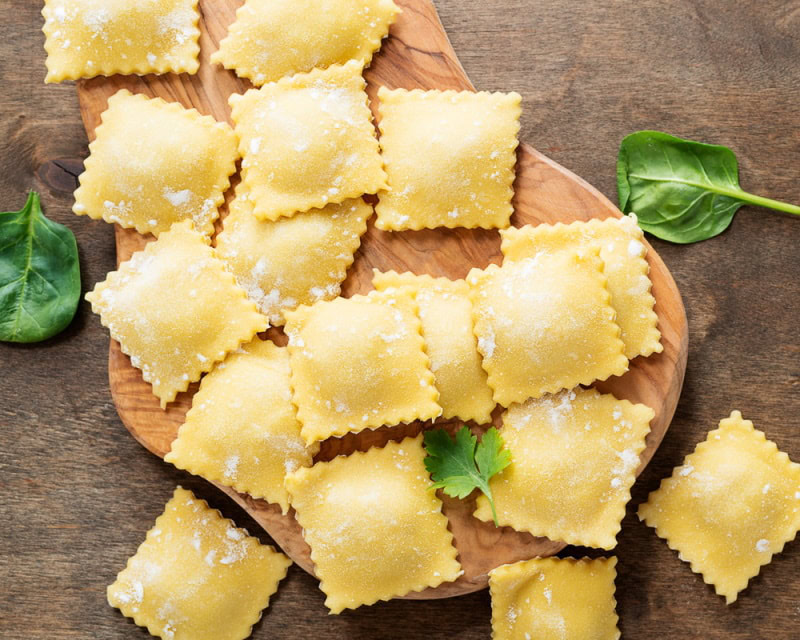 raw ravioli on wooden board