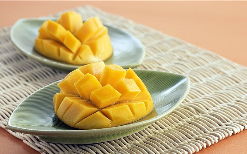 sliced mangoes on leaf-shaped saucers