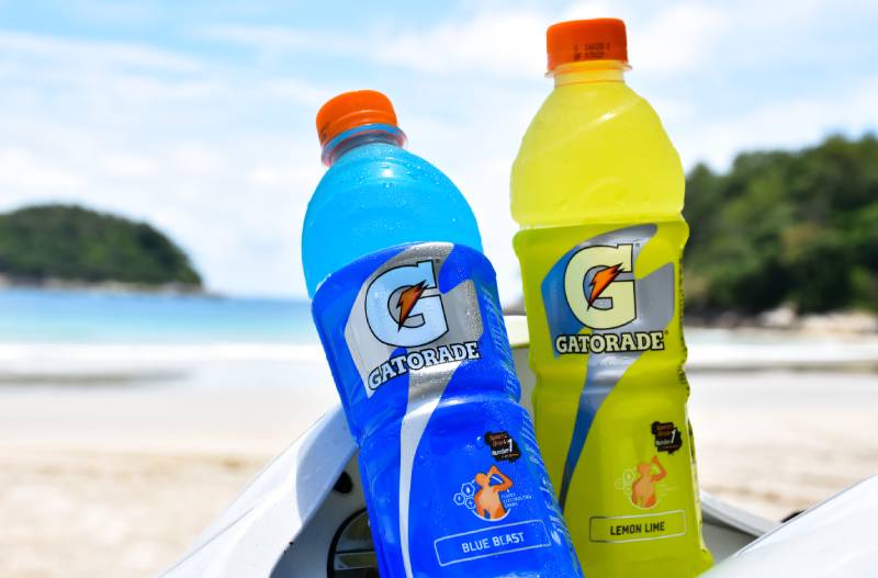 two bottles of gatorade drink with beach as background