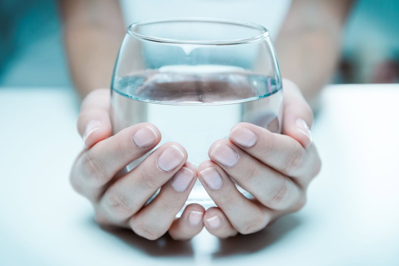 woman holding a glass of water