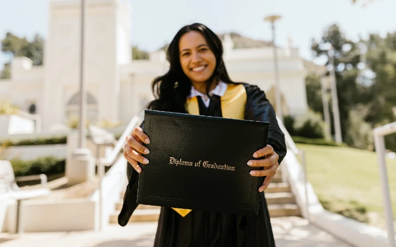 woman holding a graduation diploma