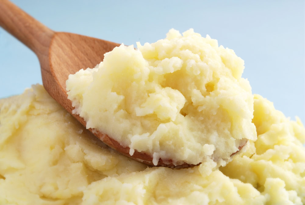 mashed potatoes on brown wooden spoon