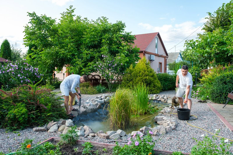 two man cleaning pond